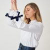Hanna’s signature pleated-sleeve shirt with velvet ribbon detail in off-white
